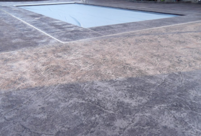 Gray stained concrete pool deck that is textured.
