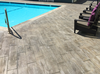 Awesome pool deck that is stamped and stained to resemble wood planks.