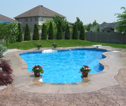 Pretty pool with a decorative concrete pool deck surrounding it.