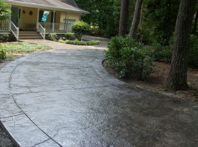 Dark stained concrete driveway that was stamped and sealed by Franklin Stamped Concrete.