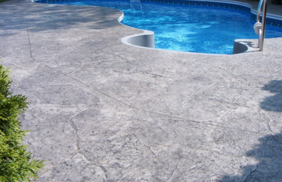 Built in pool with a textured gray pool deck.