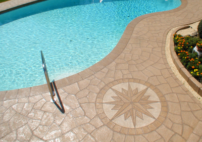 Light brown stained and stamped concrete pool deck, with decorative stamp.