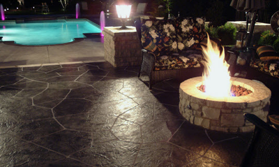 Black stained and stamped patio with a built in fire pit.