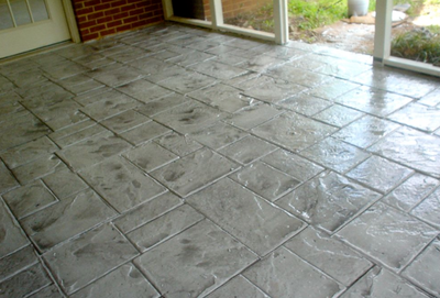 A gray paver style patio of stamped concrete for an indoor patio.